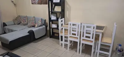 a living room with a couch and a table and chairs at The Rochester Parklane Condominium in Manila