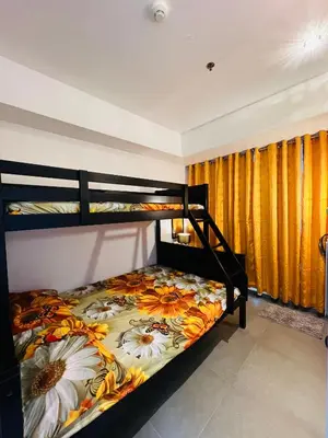 a bedroom with two bunk beds with a floral bedspread at AZURE URBAN RESORT Maldives tower in Manila