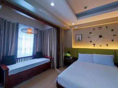 a bedroom with two beds and a clock on the wall at TWO PALMTREE VILLAS NEWPORT BOULEVARD NEAR NAIA 3 PASAY CITY in Manila