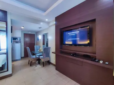 a hotel room with a television and a dining room at TWO PALMTREE VILLAS NEWPORT BOULEVARD NEAR NAIA 3 PASAY CITY in Manila