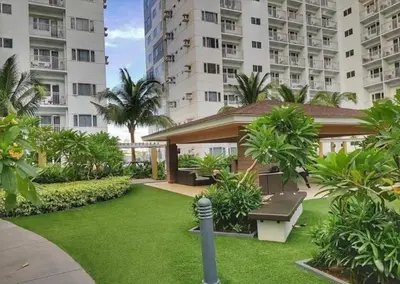 a garden with a bench and some buildings at Shore Residence D2 - shortwalk Mall of Asia Near Airport in Manila