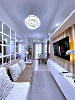 a living room with a couch and a flat screen tv at Cozypura Staycation near MOA, Airport , with free fast WIFI, Netflix and pay parking in Manila