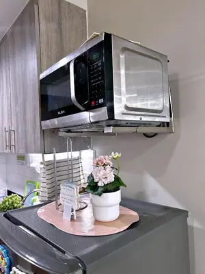 a microwave sitting on top of a kitchen counter at Cozypura Staycation near MOA, Airport , with free fast WIFI, Netflix and pay parking in Manila