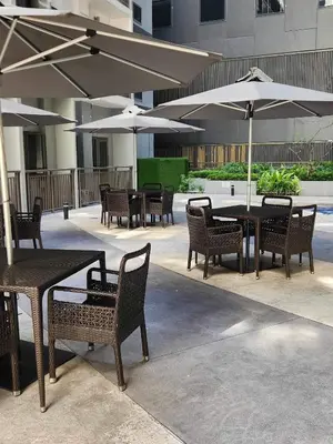 a group of tables and chairs with umbrellas at Cozypura Staycation near MOA, Airport , with free fast WIFI, Netflix and pay parking in Manila