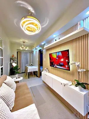 a living room with a tv on a wall at Cozypura Staycation near MOA, Airport , with free fast WIFI, Netflix and pay parking in Manila