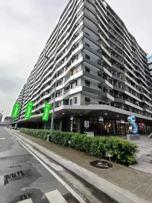 a large building with green signs in front of it at Cozypura Staycation near MOA, Airport , with free fast WIFI, Netflix and pay parking in Manila