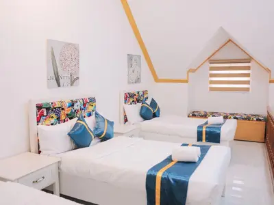 two beds in a room with white walls at Villa Excellance Beach and Wave Pool Resort in Postema