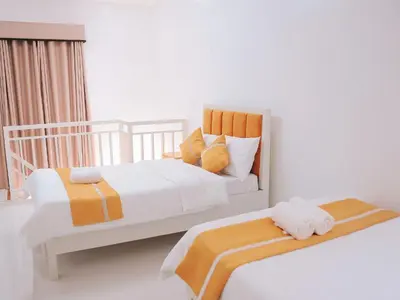 a bedroom with two beds with orange and white at Villa Excellance Beach and Wave Pool Resort in Postema