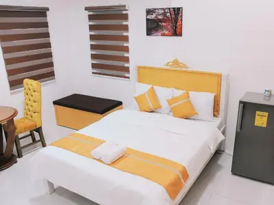 a bedroom with a large bed and a chair at Villa Excellance Beach and Wave Pool Resort in Postema