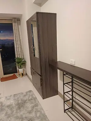 a room with a large wooden cabinet and a table at Amesha Staycation in Manila
