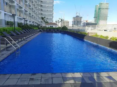a blue swimming pool on the side of a building at Amesha Staycation in Manila
