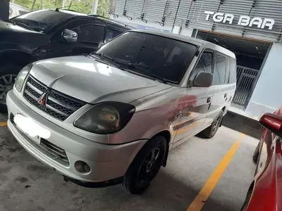 a white van parked in a parking lot at Amesha Staycation in Manila