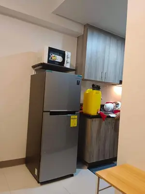 a kitchen with a refrigerator and a microwave on top of it at Amesha Staycation in Manila