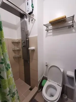 a small bathroom with a toilet and a shower at Lot's Pad nr BGC in Manila