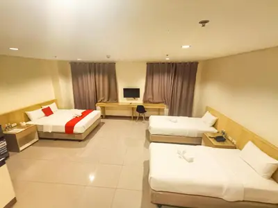 a hotel room with two beds and a television at Kaizen Suites in Manila