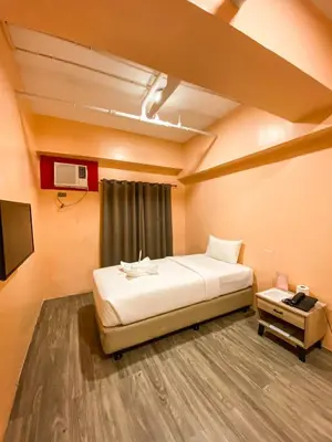 a room with a bed and a tv in it at Kaizen Suites in Manila