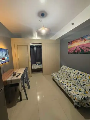 a room with a bed and a table and a desk at Sea Residences JEREMIAH2911-MALACHI310 in Manila