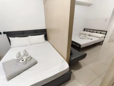 two beds in a small room with twoperate beds at Bliss Staycation at Sea Residences by John in Manila