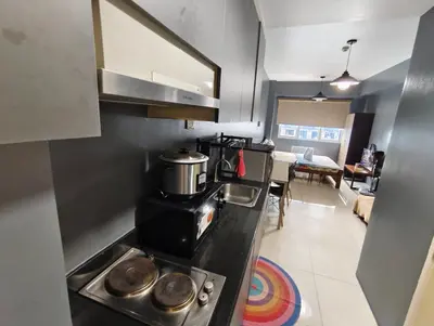 a kitchen with a stove and a counter top at Bliss Staycation at Sea Residences by John in Manila
