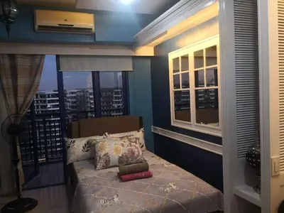a bedroom with a bed with a view of a city at Bliss Staycation at Sea Residences by John in Manila