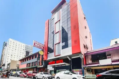 a city street with cars parked in front of a building at OYO 894 Cosmo Hotel P Campa Manila in Manila