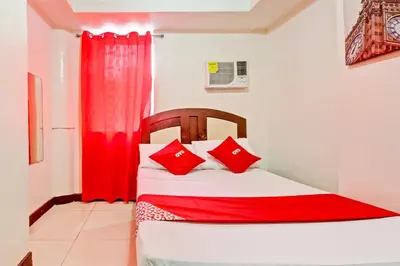 a bedroom with a bed with red pillows at OYO 894 Cosmo Hotel P Campa Manila in Manila