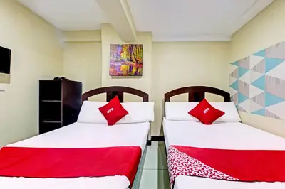 two beds in a room with red pillows at OYO 894 Cosmo Hotel P Campa Manila in Manila