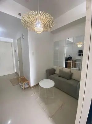 a living room with a couch and a table at 1BR unit in South Residence Las Pinas with Wifi & Netflix in Manila