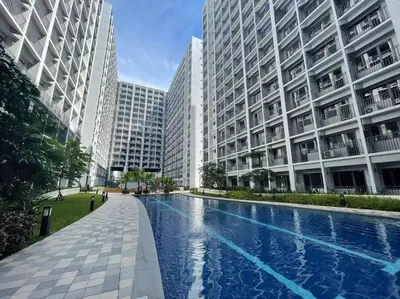 a swimming pool in the middle of two tall buildings at Fab Staycation @ MOA Complex - Fast Wifi + Netflix in Manila