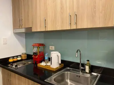a kitchen with a sink and a counter top at Fab Staycation @ MOA Complex - Fast Wifi + Netflix in Manila