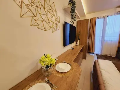 a living room with a table with yellow flowers on it at Fab Staycation @ MOA Complex - Fast Wifi + Netflix in Manila