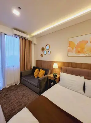 a hotel room with a bed and a couch at Fab Staycation @ MOA Complex - Fast Wifi + Netflix in Manila