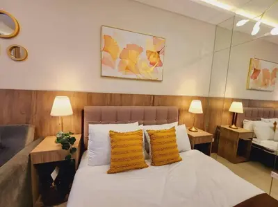 a bedroom with a white bed with two yellow pillows at Fab Staycation @ MOA Complex - Fast Wifi + Netflix in Manila