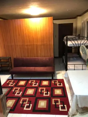 a room with two bunk beds and a rug at THE MANSION - 24-HOUR Near AirPort Hostel 4 Backpackers in Manila