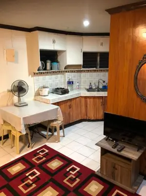 a large kitchen with a table and a counter top at THE MANSION - 24-HOUR Near AirPort Hostel 4 Backpackers in Manila