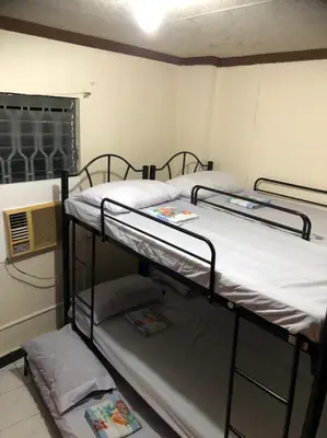 two bunk beds in a room with a window at THE MANSION - 24-HOUR Near AirPort Hostel 4 Backpackers in Manila