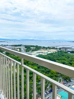 a balcony with a view of a city and the ocean at 1 Bedroom Condo near CCP Roxas Boulevard Pasay in Manila