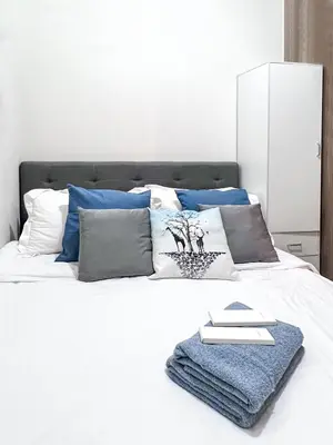 a bedroom with a white bed with blue pillows at 1 Bedroom Condo near CCP Roxas Boulevard Pasay in Manila