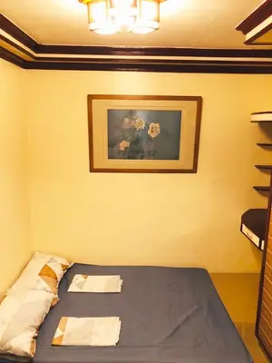 a bedroom with a bed with two towels on it at THE MANSION - BACKPACKERS Near AIRPORT in Manila