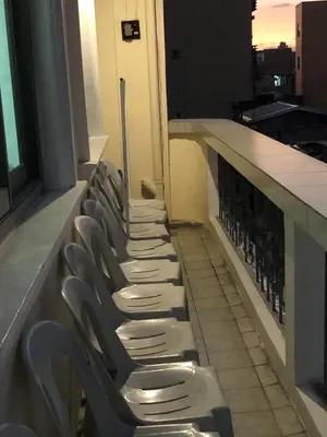 a row of chairs lined up on a balcony at THE MANSION - BACKPACKERS Near AIRPORT in Manila