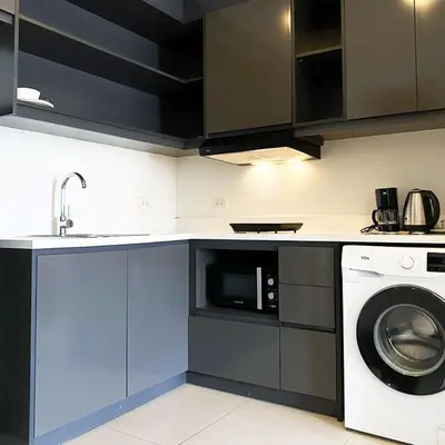 a kitchen with a washing machine and a microwave at The Residences at BCCT in Manila