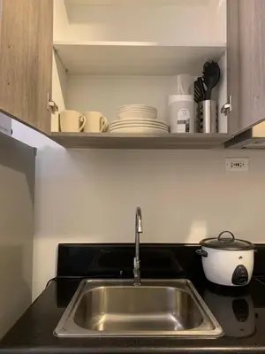 a kitchen counter with a sink and a shelf with dishes at SMDC Coast Residences Roxas Boulevard corner Pasay Condo Unit in Manila