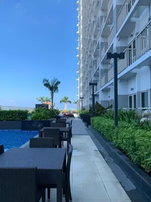 a patio with tables and chairs next to a building at SMDC Coast Residences Roxas Boulevard corner Pasay Condo Unit in Manila
