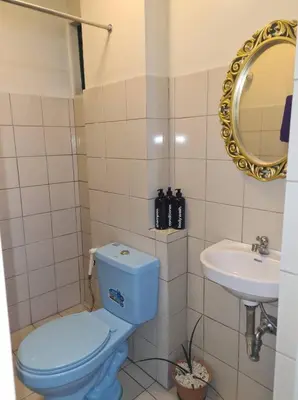 a bathroom with a blue toilet and a sink at Pet Friendly Staycation in in Cainta