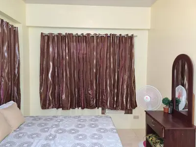 a bedroom with a bed and a window with curtains at Pet Friendly Staycation in in Cainta