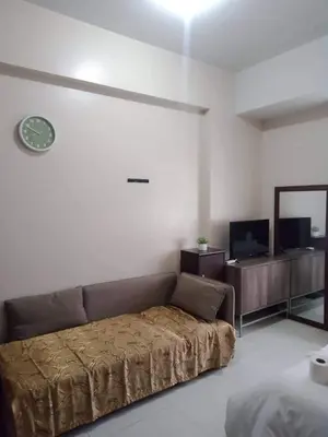 a bedroom with a couch and a tv in it at 101 Newport Boulevard -Terminal 3 Airport in Manila