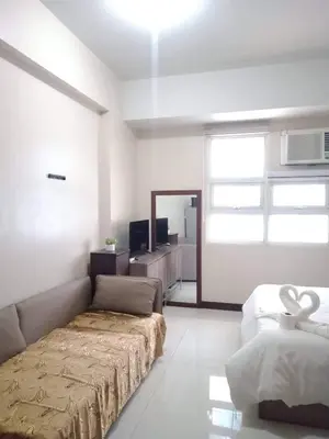 a room with a bed and a couch and a window at 101 Newport Boulevard -Terminal 3 Airport in Manila