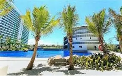 a group of palm trees in front of a building at Azure Beach Resort A5 Near Mall Airport in Manila