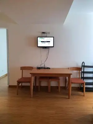 a table and chairs with a television on a wall at Azure Beach Resort A5 Near Mall Airport in Manila