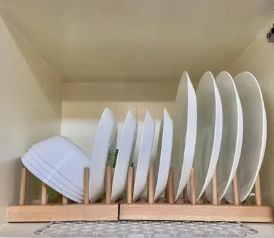 a row of white plates in a wooden rack at Althea's Cozy Home - Condo in Las Pinas in Manila